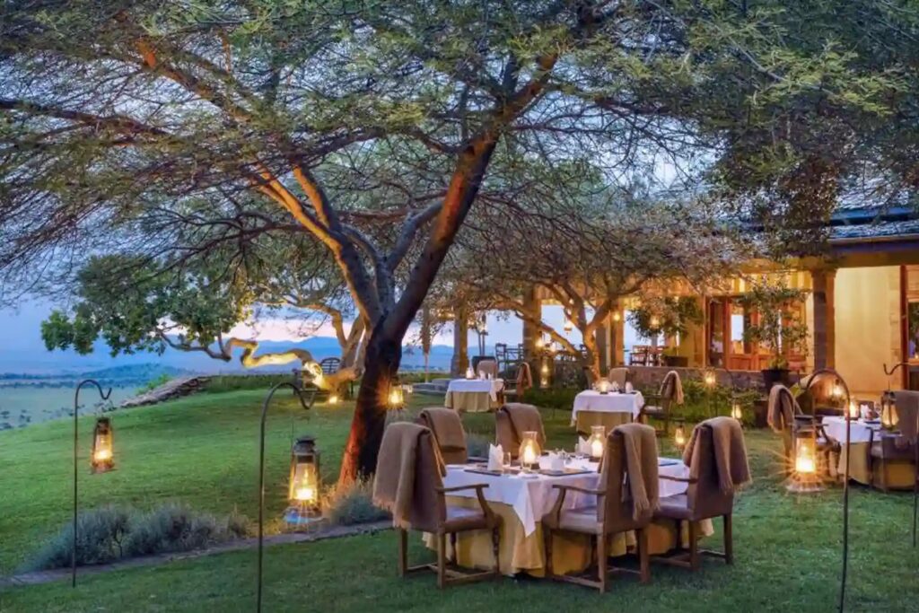 Private lantern-lit bush dinner at a luxury safari lodge in Tanzania with candlelit tables beneath acacia trees